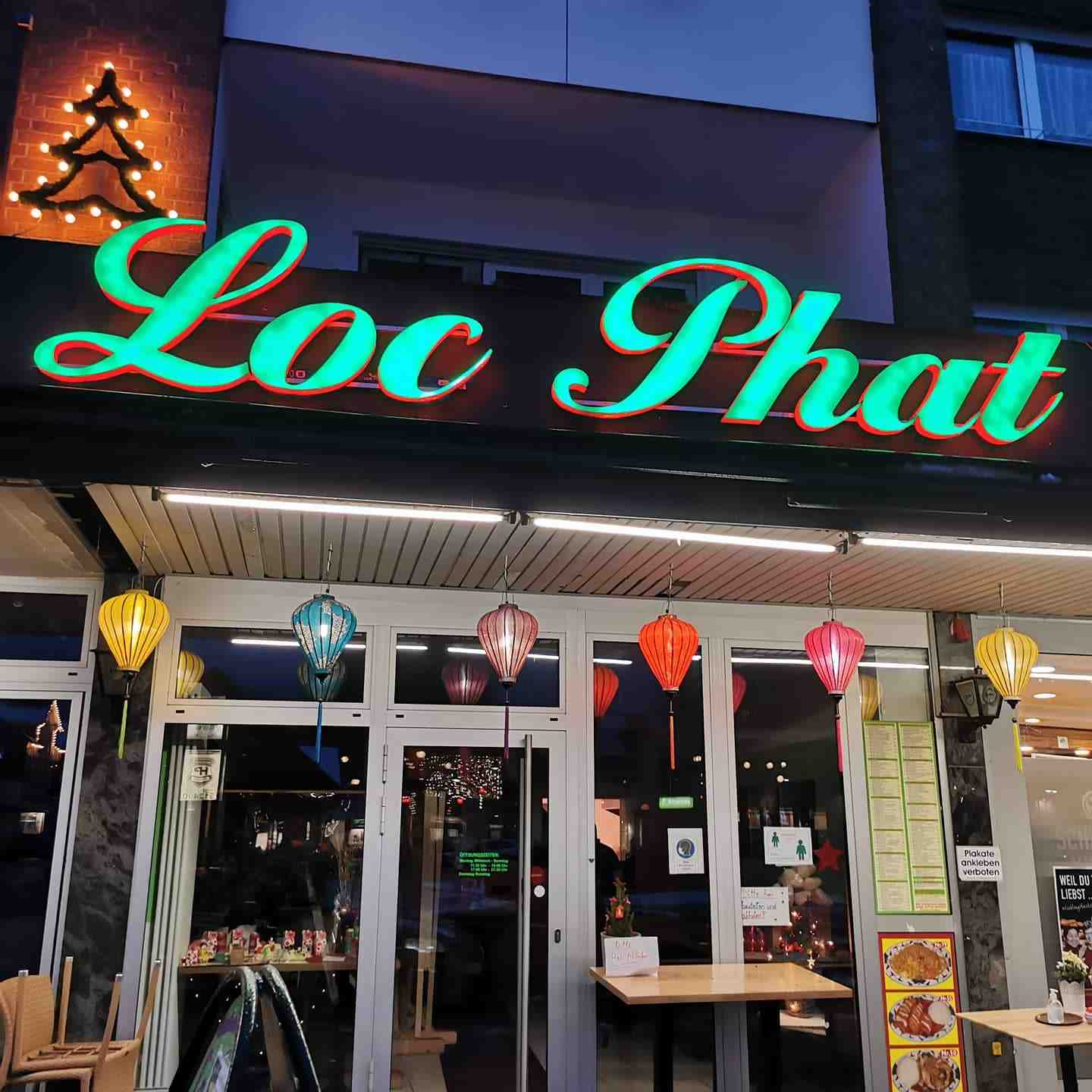Beleuchteter Loc-Phat-Restaurantschriftzug mit grüner Front und roter Lichtkante